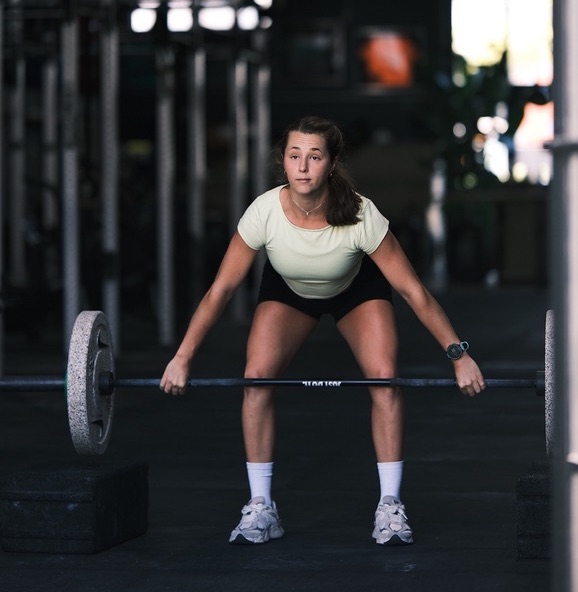 Coach performing a deadlift in the gym
